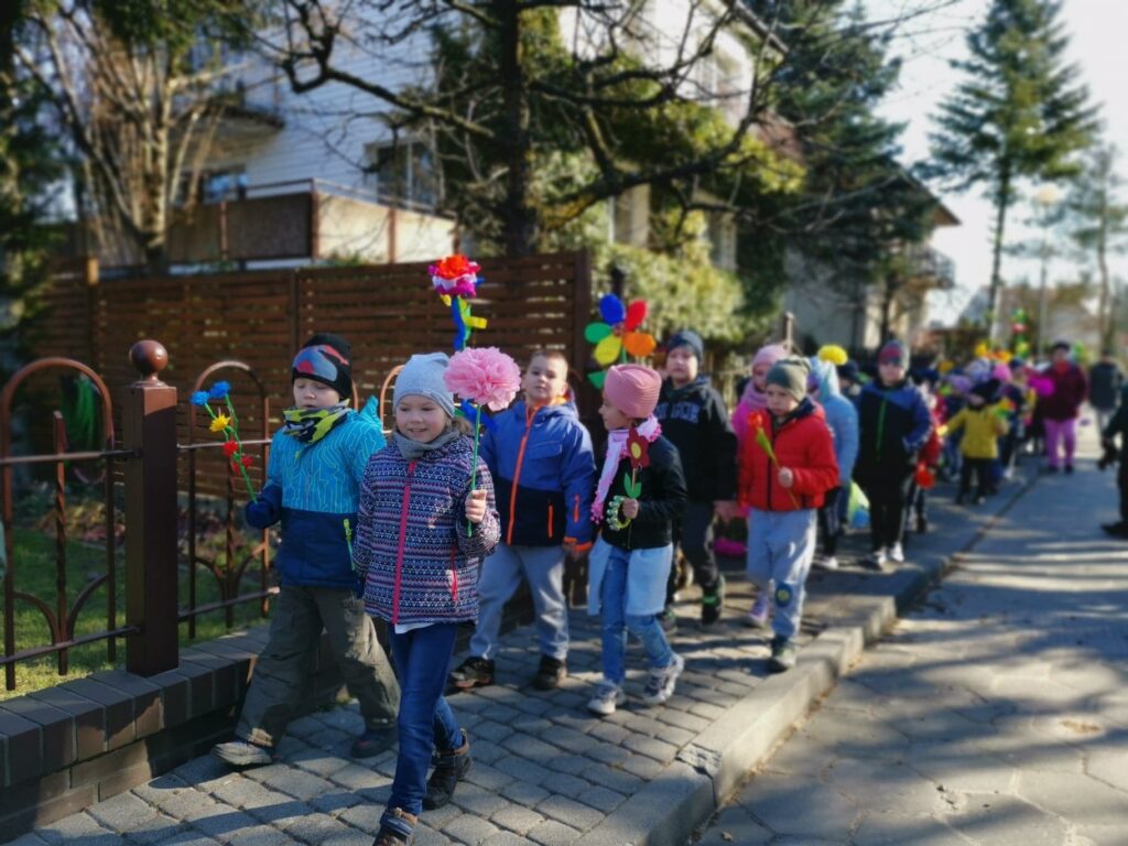 Dzieci idą w wiosennym korowodzie.